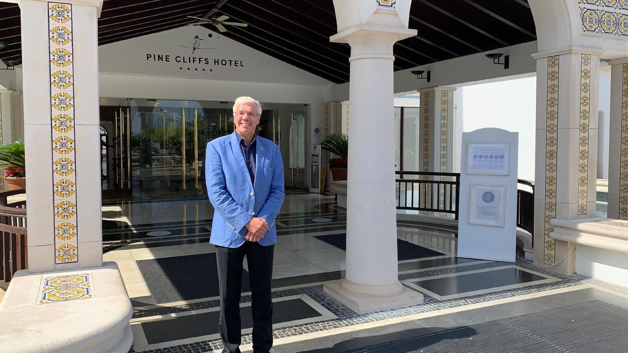 Ein älterer Mann steht vor einem Hotel in Portugal. Ein älterer Mann steht vor einem Hotel in Portugal.