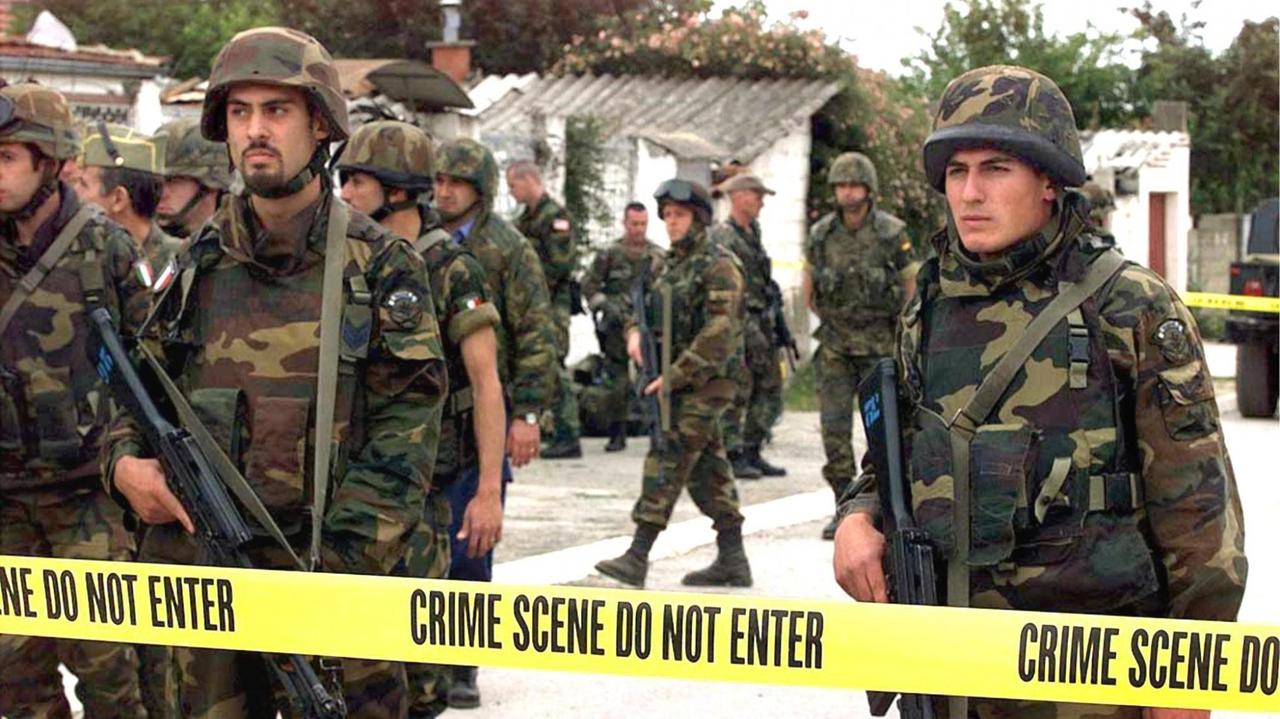 US-Soldaten hinter Flatterband - sie sperren ein Gelände, auf der Suche nach Spuren von Kriegsverbrechen (1999 im Kosovo). US-Soldaten hinter Flatterband - sie sperren ein Gelände, auf der Suche nach Spuren von Kriegsverbrechen (1999 im Kosovo).
