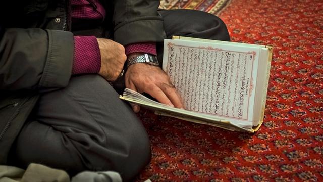 Ein iranischer Muslim liest während des Gottesdienstes in der Moschee im Koran.