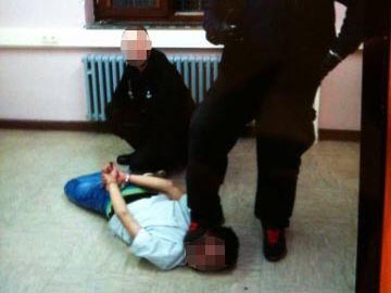 Zwei Sicherheitsleute misshandeln in der ehemaligen Siegerland-Kaserne in Burbach (Nordrhein-Westfalen) einen am Boden liegenden Flüchtling.