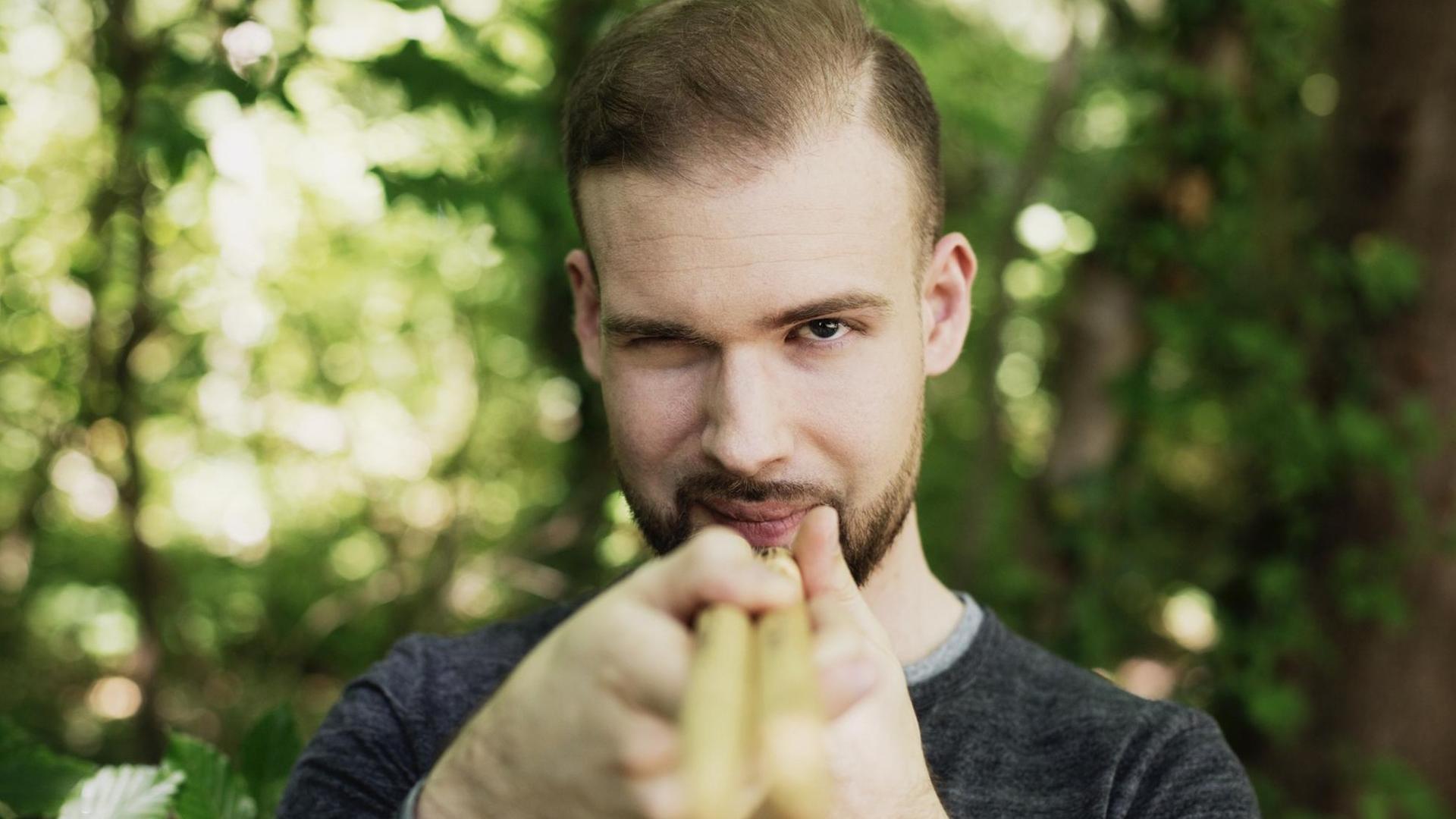 Der Muisker steht im Wald und nimmt den Betrachter mit seinen Drumsticks ins Visier Der Muisker steht im Wald und nimmt den Betrachter mit seinen Drumsticks ins Visier