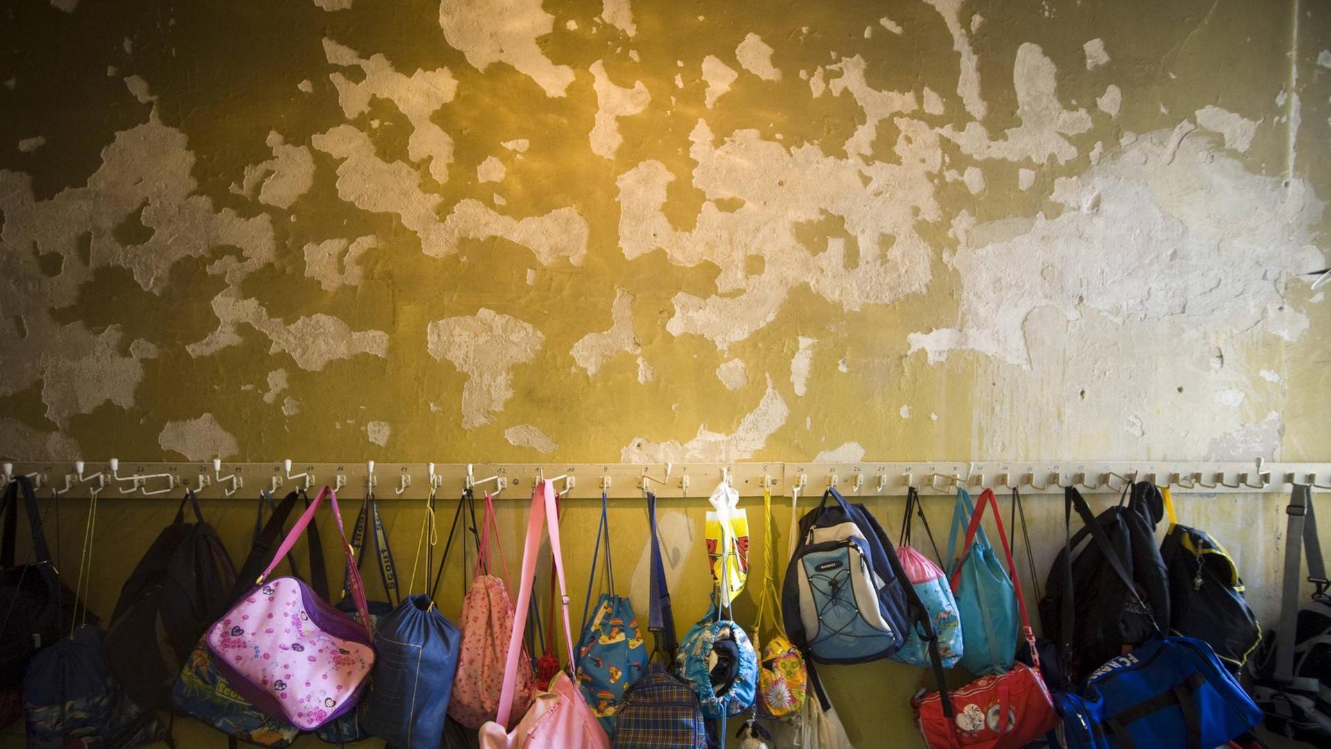 Rucksäcke hängen an einer Garderoba in einer sanierungsbedürftigen Grundschule in Berlin (13.02.2009).