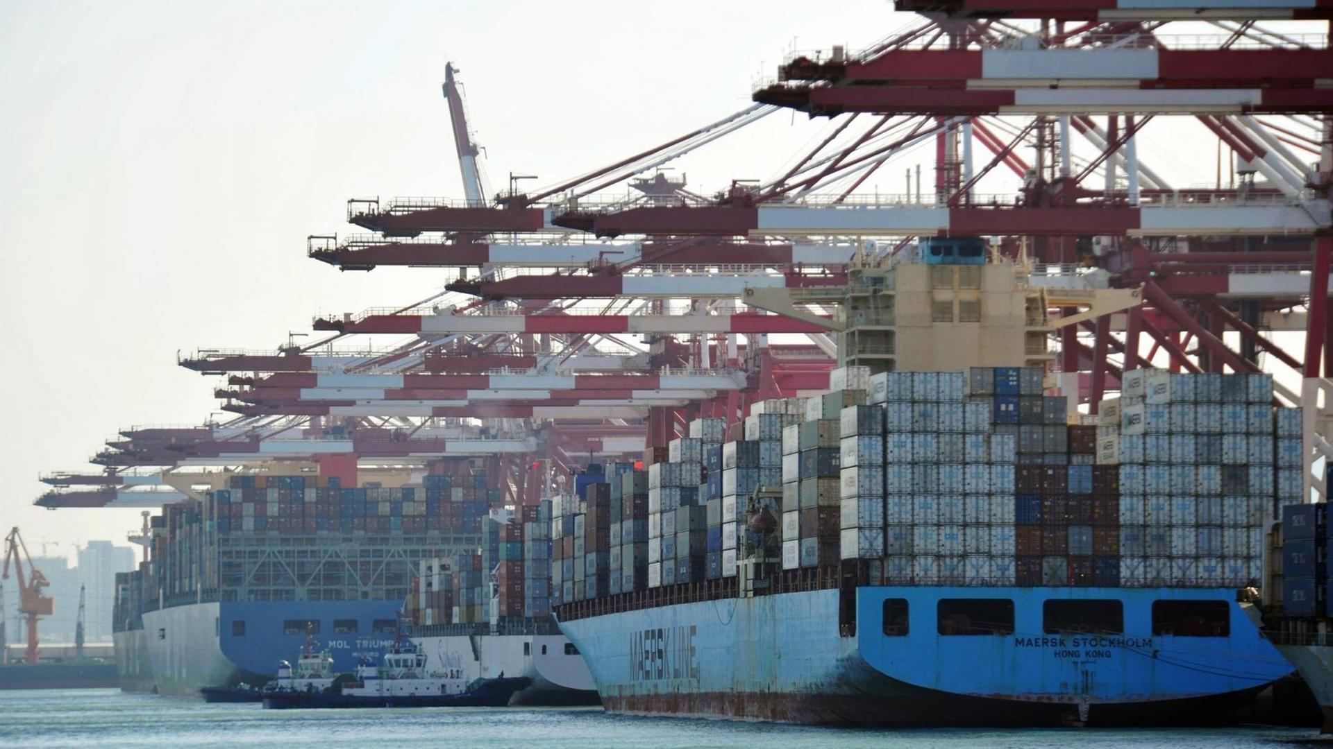 Schiffe mit Containern im Hafen von Qingdao in China