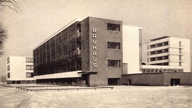 Ein Schwarzweißfoto des Bauhaus in Dessau: Ein eleganter Bau in klarer Formgebung.