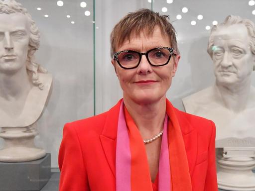 Die neue Präsidentin der Klassik Stiftung Weimar steht zwischen zwei männlichen Büsten.