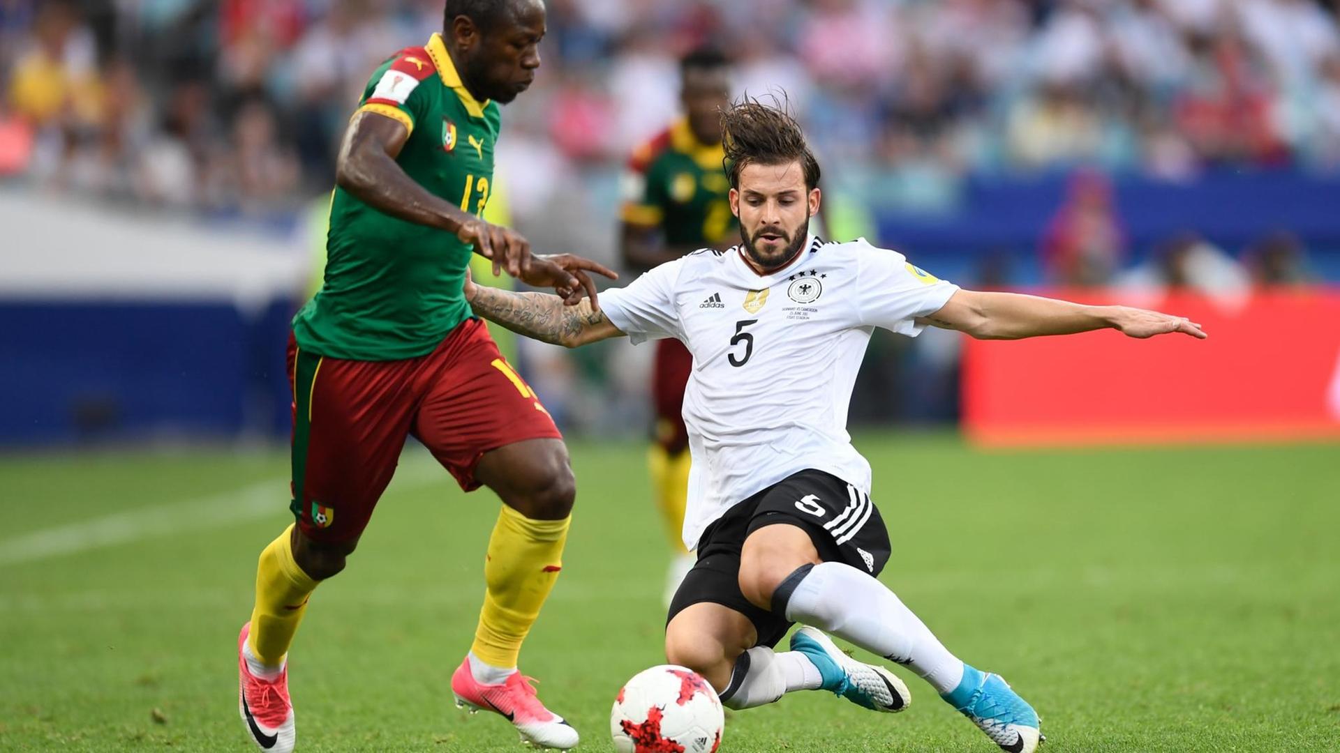 Der deutsche Fußballer Marvin Plattenhardt (r) und der kamerunische Spieler Christian Bassogog kämpfen beim Vorrundenspiel des Fußball-Confed-Cup zwischen Deutschland und Kamerun um den Ball. Der deutsche Fußballer Marvin Plattenhardt (r) und der kamerunische Spieler Christian Bassogog kämpfen beim Vorrundenspiel des Fußball-Confed-Cup zwischen Deutschland und Kamerun um den Ball.