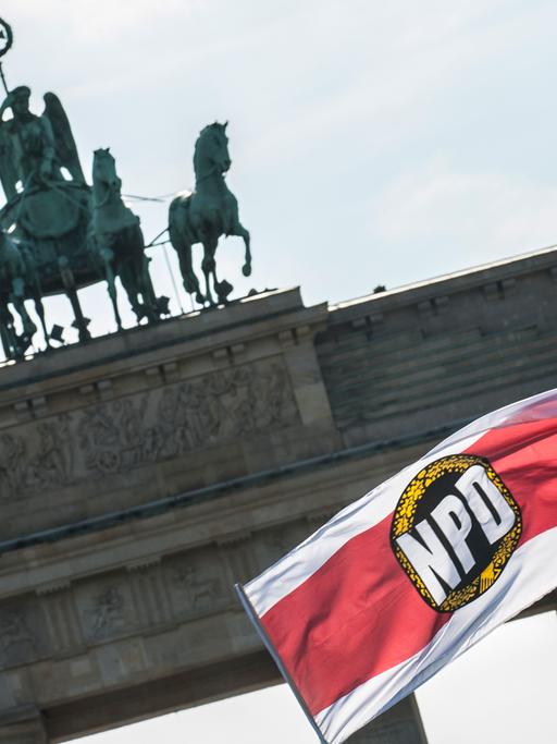 Eine Fahne der NPD weht in Berlin bei einer Demonstration der rechtsextremen Partei auf dem Pariser Platz vor dem Brandenburger Tor.
