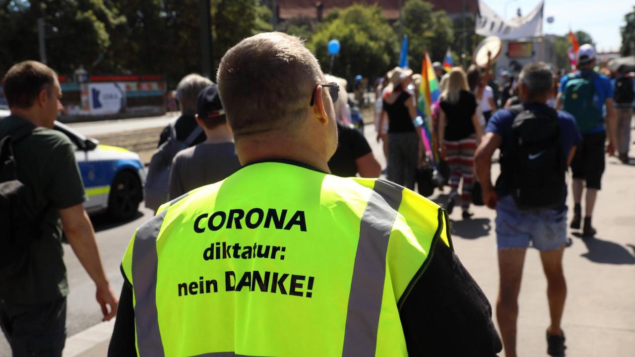 Auf der neongelben Jacke eines Demonstranten steht: "Corona-Diktatur Nein Danke". Auf der neongelben Jacke eines Demonstranten steht: "Corona-Diktatur Nein Danke".