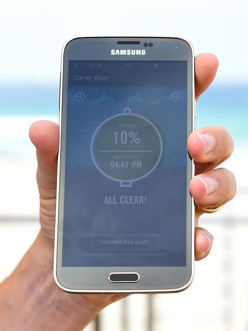 Chris Anderson von Shark Mitigation Systems zeigt am 15.2.2016 die Smartphone App, mit der die Lifeguards am Bondi Beach im australischen Sydney die Daten der intelligenten Boje Clever Buoy nutzen können.