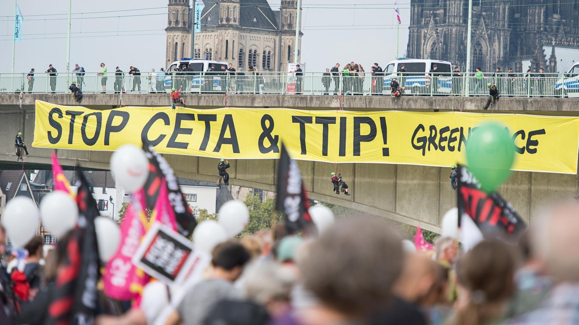 Aktivisten von Greanpeace bringen ein Banner an der Deutzer Brücke an am 17.09.2016, bei einer Demonstration gegen die Handelsabkommen CETA und TTIP in Köln (Nordrhein-Westfalen). Aktivisten von Greanpeace bringen ein Banner an der Deutzer Brücke an am 17.09.2016, bei einer Demonstration gegen die Handelsabkommen CETA und TTIP in Köln (Nordrhein-Westfalen).