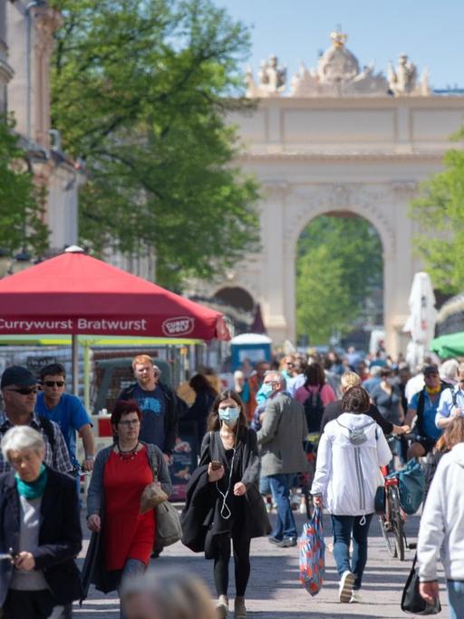 Zahlreiche Passanten schlendern mit Mundschutz durch die Innenstadt von Potsdam in Brandenburg.