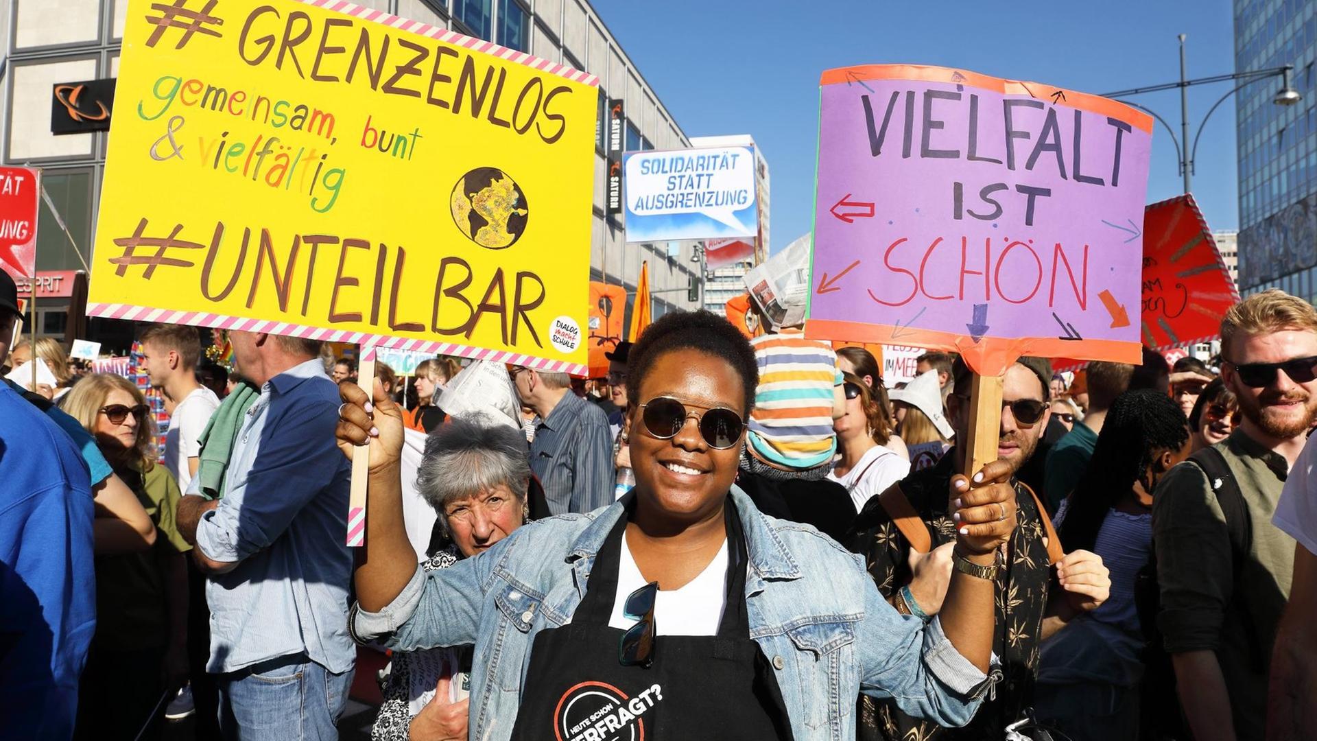 Eine Frau hält in einer Menge von Demonstrationen vor dem U-Bahnhof Alexanderplatz das Schild "Vielfalt ist schön" nach oben Eine Frau hält in einer Menge von Demonstrationen vor dem U-Bahnhof Alexanderplatz das Schild "Vielfalt ist schön" nach oben