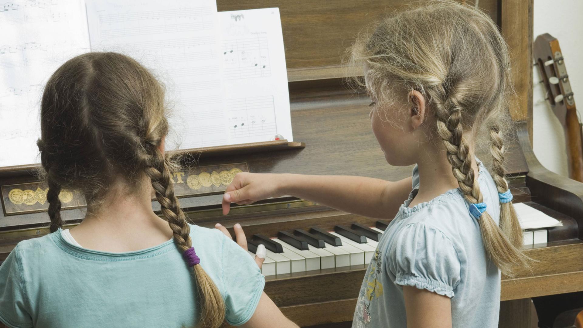 Zwei Mädchen spielen Klavier Zwei Mädchen spielen Klavier