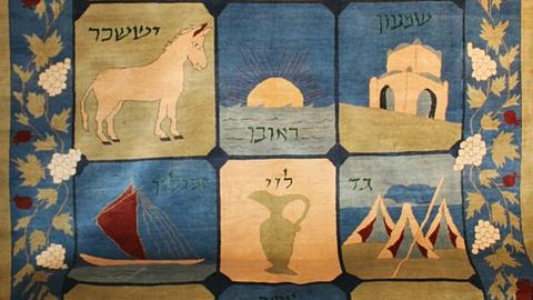Ein Teppich mit verschiedenen Motiven, ein Schiff, ein Einhorn, einen Krug oder Tempel.