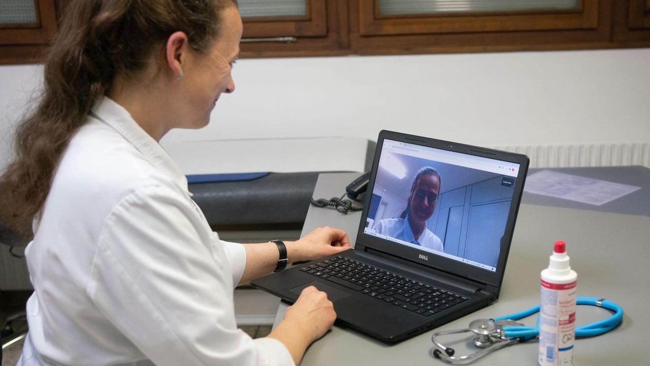 Eine Fachärztin für Allgemeinmedizin demonstriert in ihrer Praxis den Ablauf einer Videosprechstunde Eine Fachärztin für Allgemeinmedizin demonstriert in ihrer Praxis den Ablauf einer Videosprechstunde