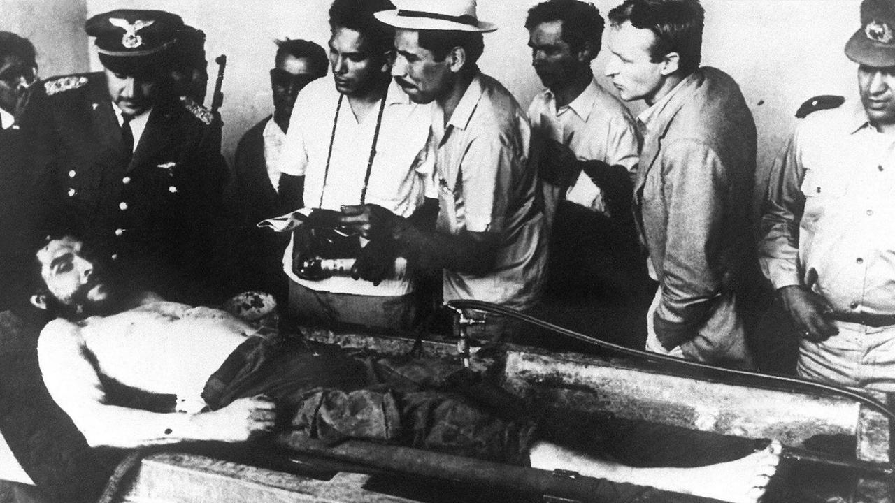 Die Leiche des kubanischen Revolutionärs Ernesto "Che" Guevara wird einen Tag nach seiner Hinrichtung am 9.10.1967 in Valle Grande (Bolivien) zur Schau gestellt. Der am 14.6.1928 in Rosario (Argentinien) geborene Arzt beteiligte sich am Aufbau der Volksbefreiungsarmee des Kubaners Fidel Castro. Nach dem Sieg der Revolutionäre nahm er am 9.2.1959 die kubanische Staatsbürgerschaft an. Guevara war Präsident der kubanischen Nationalbank (1959-1961) und Industrieminister (ab 1961). 1965 brach er mit Fidel Castro und trat am 14.3. von allen Staatsämtern zurück, tauchte unter und ging Ende 1966 als Guerilla-Führer nach Bolivien, wo er am 9.10.1967 erschossen wurde. Für die 68er Generation war er eine der führenden linken Leitfiguren. | Die Leiche des kubanischen Revolutionärs Ernesto "Che" Guevara wird einen Tag nach seiner Hinrichtung am 9.10.1967 in Valle Grande (Bolivien) zur Schau gestellt. Der am 14.6.1928 in Rosario (Argentinien) geborene Arzt beteiligte sich am Aufbau der Volksbefreiungsarmee des Kubaners Fidel Castro. Nach dem Sieg der Revolutionäre nahm er am 9.2.1959 die kubanische Staatsbürgerschaft an. Guevara war Präsident der kubanischen Nationalbank (1959-1961) und Industrieminister (ab 1961). 1965 brach er mit Fidel Castro und trat am 14.3. von allen Staatsämtern zurück, tauchte unter und ging Ende 1966 als Guerilla-Führer nach Bolivien, wo er am 9.10.1967 erschossen wurde. Für die 68er Generation war er eine der führenden linken Leitfiguren. |