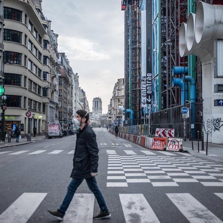 Ein Mann läuft am 17. März mit einer Schutzmaske vor dem Pariser Centre Pompidou über die Straße.