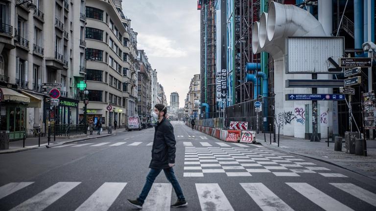 Ein Mann läuft am 17. März mit einer Schutzmaske vor dem Pariser Centre Pompidou über die Straße.