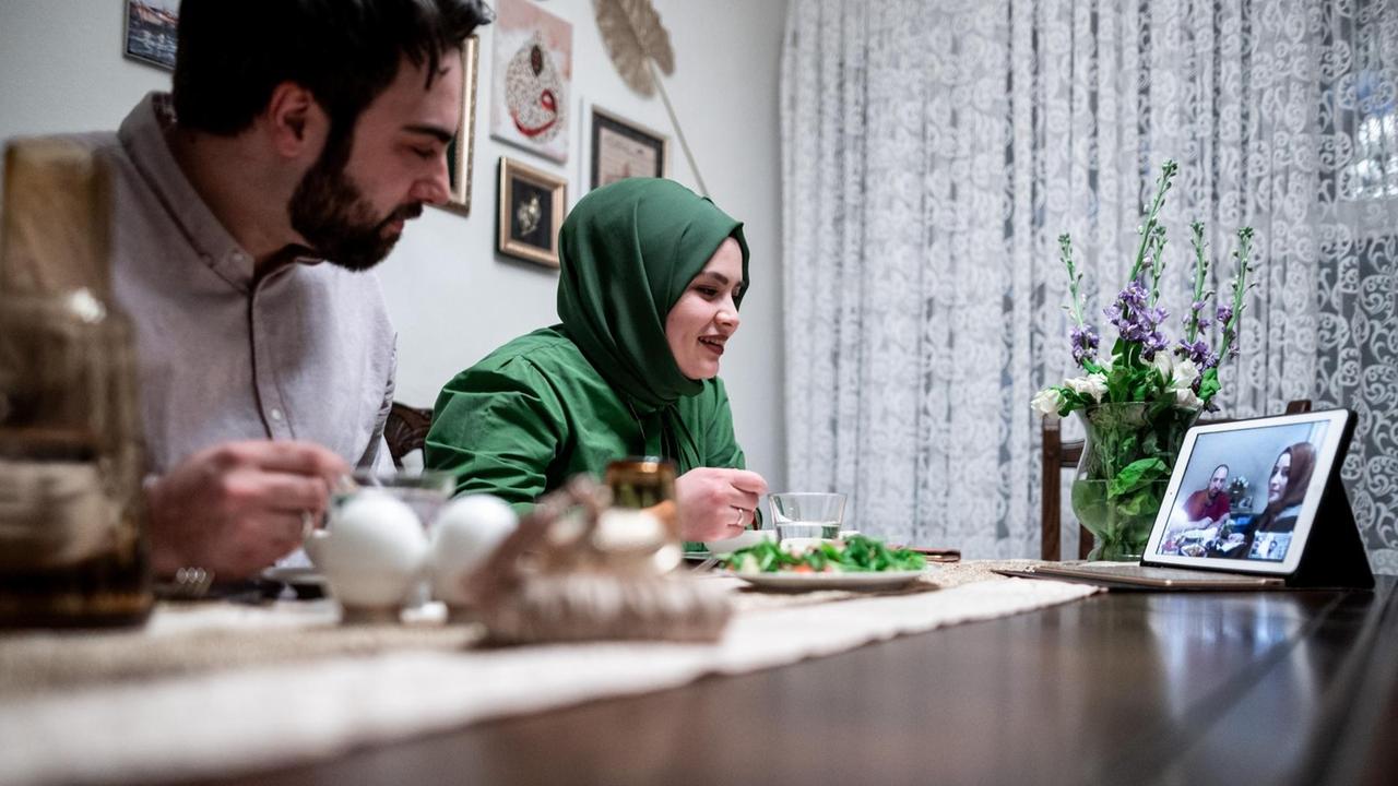 Ein Mann und eine Frauen essen und schauen dabei auf ein Tablet. Ein Mann und eine Frauen essen und schauen dabei auf ein Tablet.