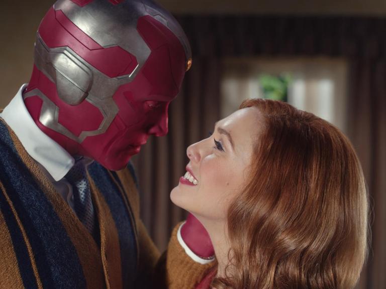 Mann mit Maske und Frau sehen sich an: Paul Bettany als VIsion and Elizabeth Olsen als Wanda Maximoff in der Serie "WandaVision".