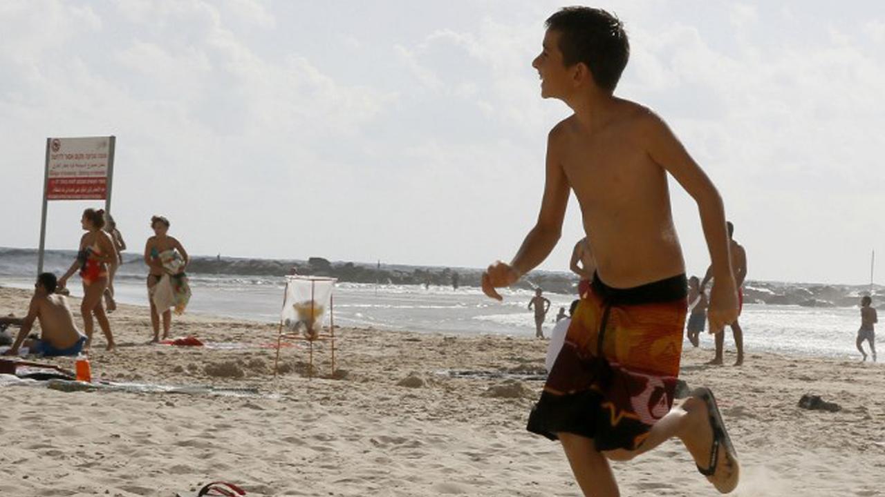 Während eines Raketenangriffs läuft ein Junge im Strand. Während eines Raketenangriffs läuft ein Junge im Strand.