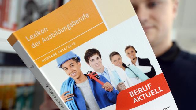 Ein Mann liest in der Agentur für Arbeit in Halle (Saale) (Sachsen-Anhalt) in einer Broschüre zur Berufsausbildung.