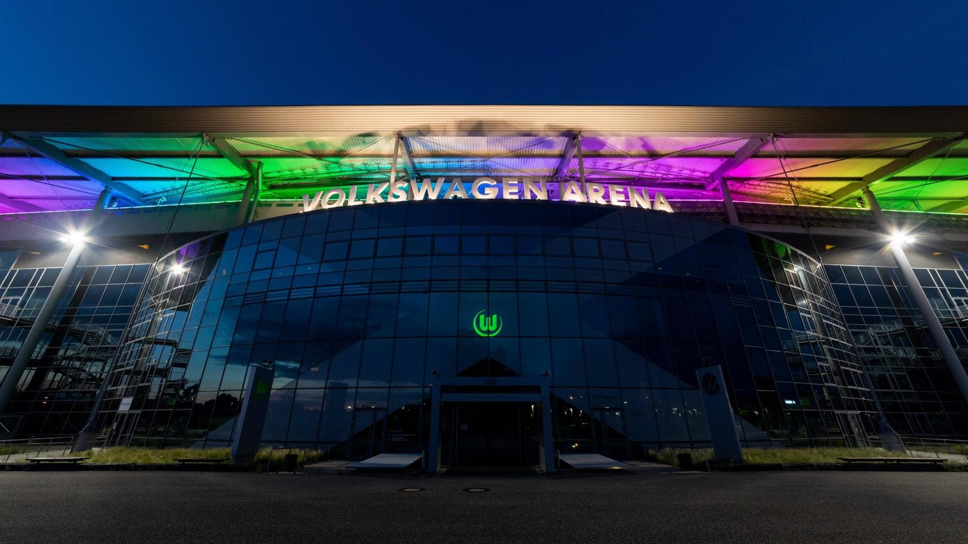 Das Stadion des VfL Wolfsburg erstrahlt vor einem dunklen Himmel in Regenbogenfarben. Das Stadion des VfL Wolfsburg erstrahlt vor einem dunklen Himmel in Regenbogenfarben.