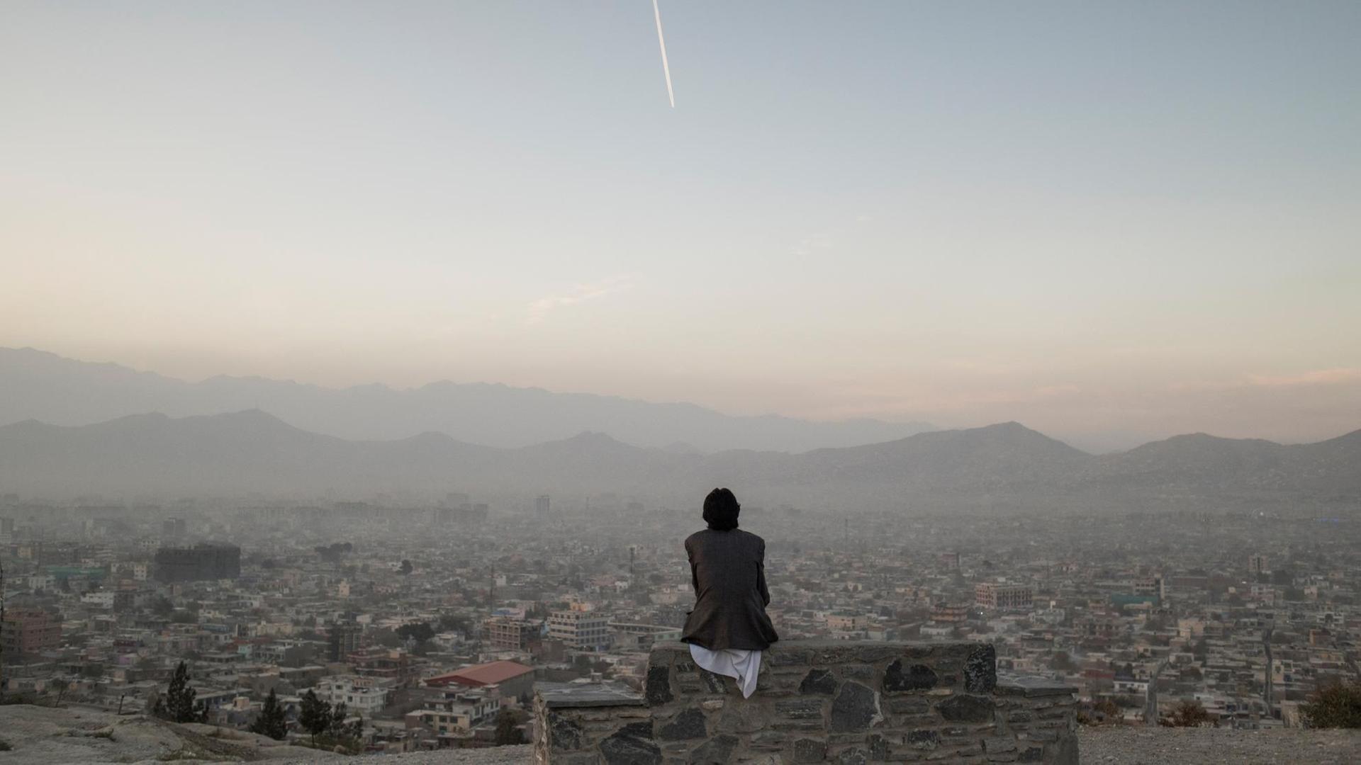 Ein Mann schaut über das Stadtpanorama von Kabul