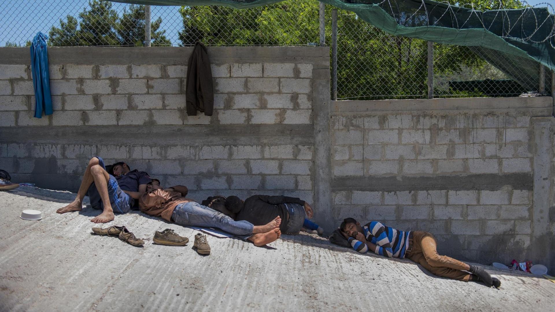 Flüchtlinge aus Afghanistan liegen auf der griechischen Insel Lesbos auf einer Straße . Flüchtlinge aus Afghanistan liegen auf der griechischen Insel Lesbos auf einer Straße .