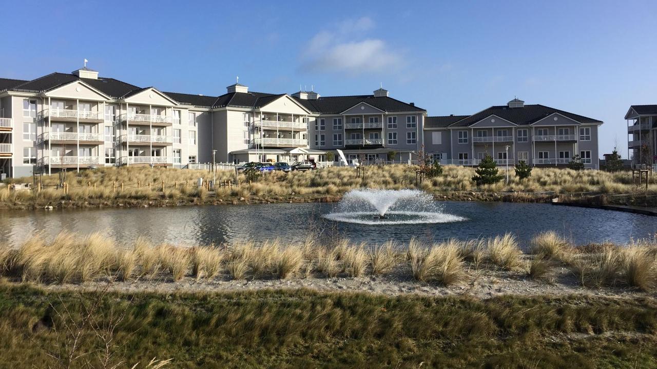 Beach Motel in Heiligenhafen, davor ein Teich mit Springbrunnen und Gräsern Beach Motel in Heiligenhafen, davor ein Teich mit Springbrunnen und Gräsern