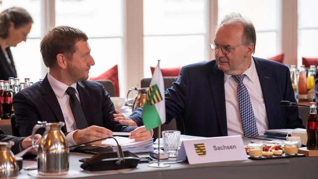 Michael Kretschmer (CDU), Ministerpräsident von Sachsen und Reiner Haseloff (CDU), Ministerpräsident von Sachsen-Anhalt, sitzen an einem Konferenztisch nebeneinander.