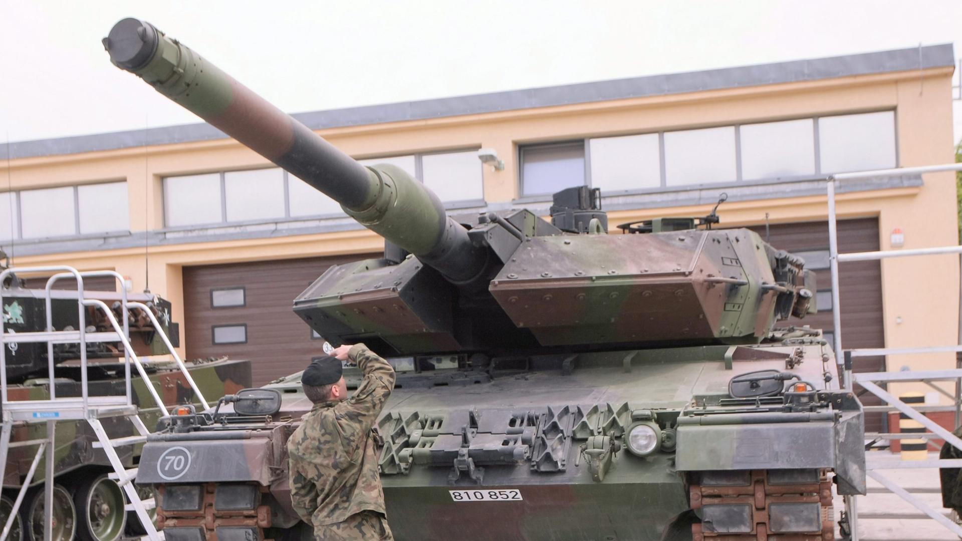 Ein Soldat begutachtet einen deutschen Leopard-Panzer. Ein Soldat begutachtet einen deutschen Leopard-Panzer.