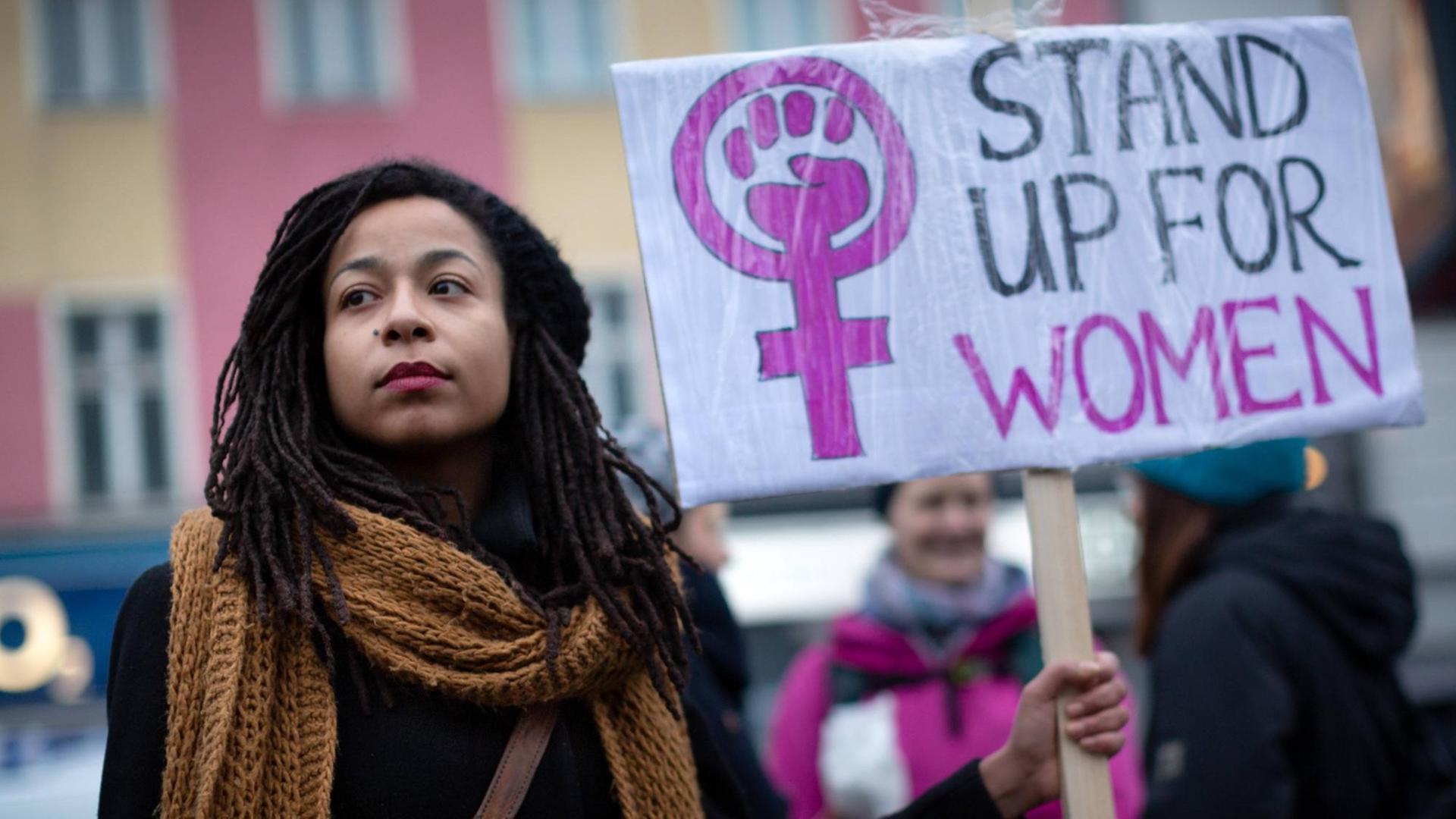 Das Foto zeigt eine junge Demonstrantin auf dem internationalen Frauentag vom 8. März 2019. Sie hält ein Schild mit der Aufschrift: "Stand up for women"