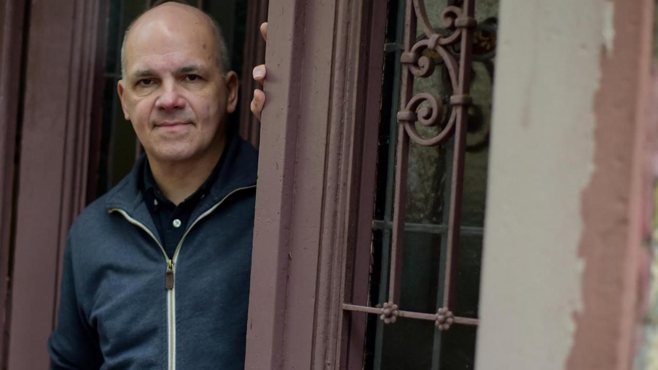 Der Schriftsteller Frank Witzel steht lässig in einem Hauseingang und blickt auf die Straße Der Schriftsteller Frank Witzel steht lässig in einem Hauseingang und blickt auf die Straße
