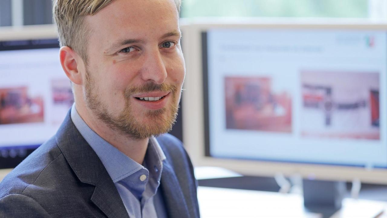 Christoph Hebbecker sitzt in seinem Büro, im Hintergrund stehen Bildschirme. Christoph Hebbecker sitzt in seinem Büro, im Hintergrund stehen Bildschirme.