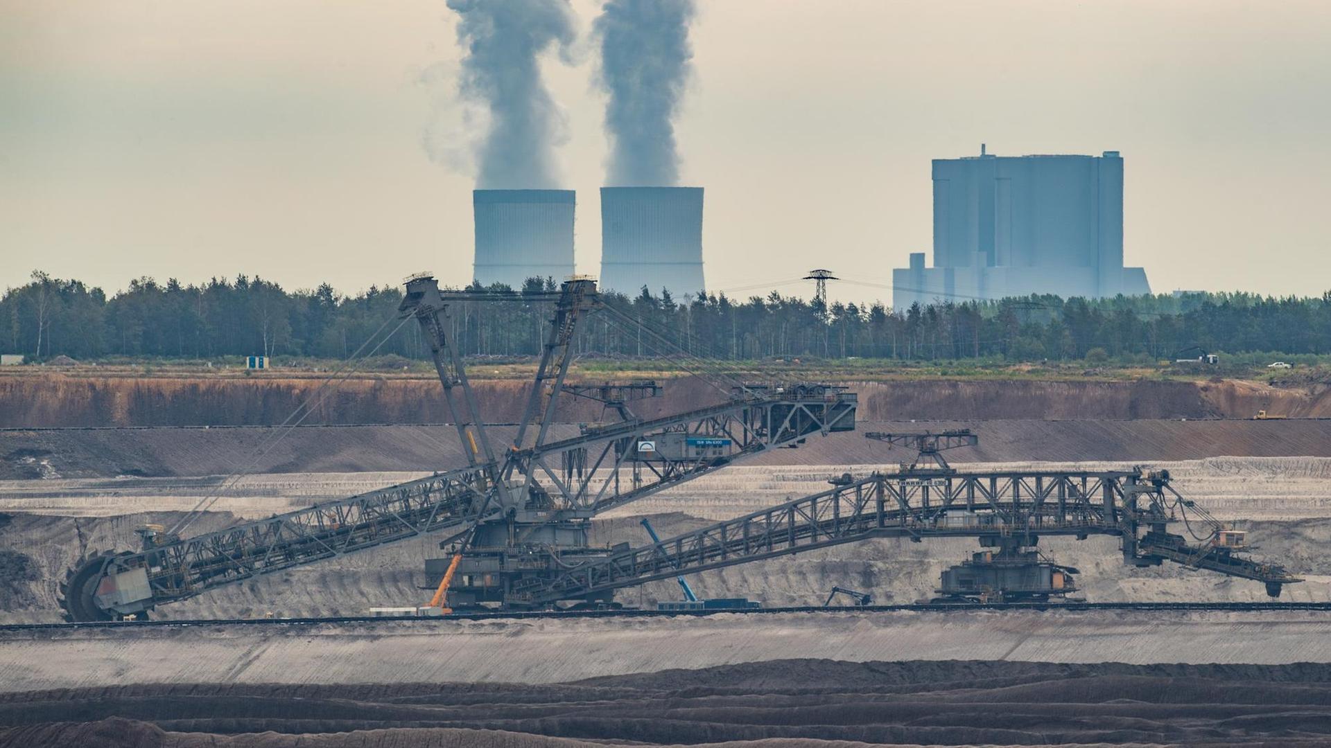 Ein Schaufelradbagger steht im Braunkohletagebau Welzow-Süd der Lausitz Energie Bergbau AG (LEAG). Dahinter steigt Wasserdampf aus den Kühltürmen des Braunkohlekraftwerkes Schwarze Pumpe. Ein Schaufelradbagger steht im Braunkohletagebau Welzow-Süd der Lausitz Energie Bergbau AG (LEAG). Dahinter steigt Wasserdampf aus den Kühltürmen des Braunkohlekraftwerkes Schwarze Pumpe.