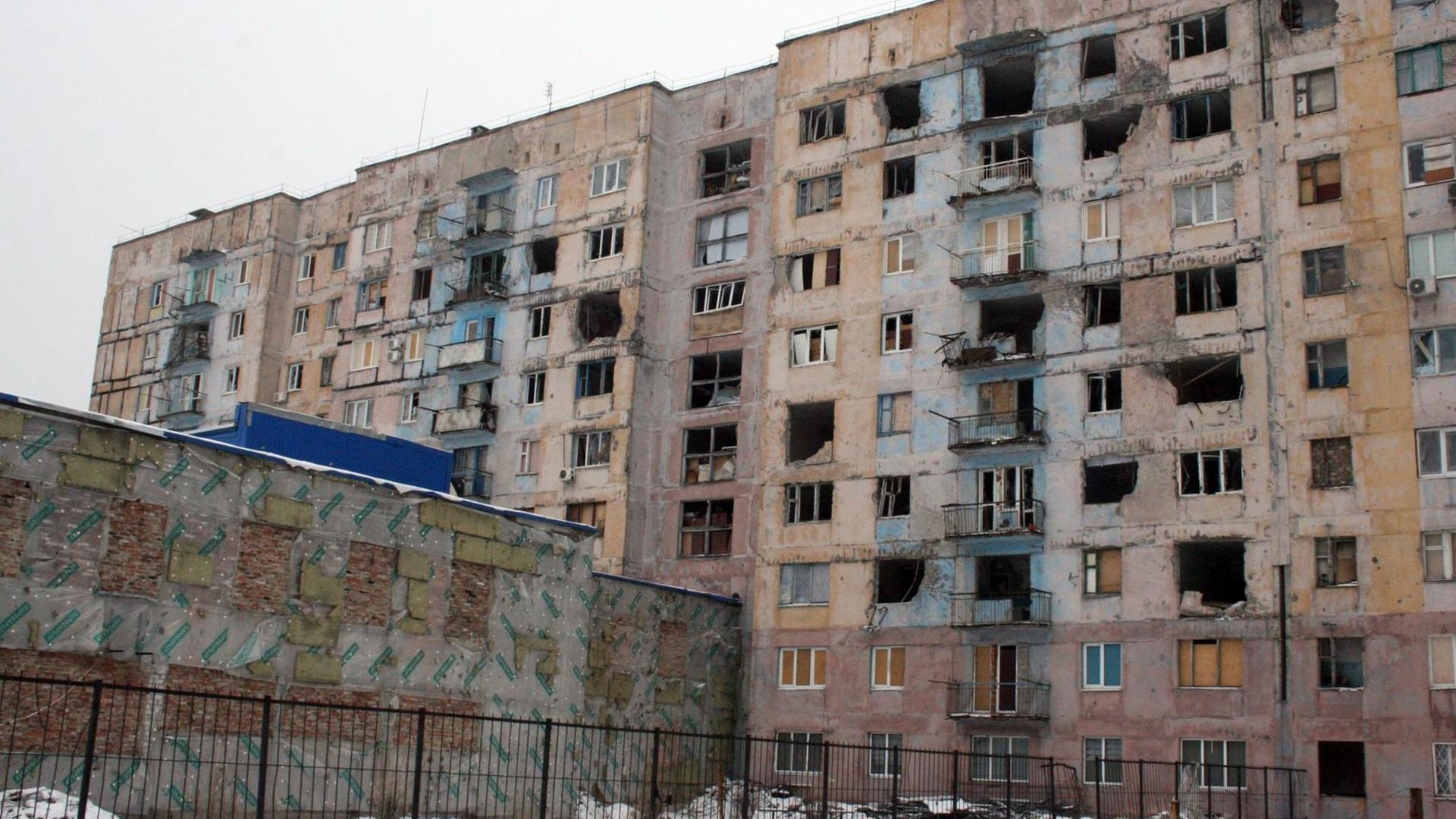 Das Bild zeigt einen zerstörten Wohnblock in Awdijiwka (Ukraine). Die Kleinstadt liegt an der Front zu den Seperatisten, der Wiederaufbau geht nur schleppend voran.