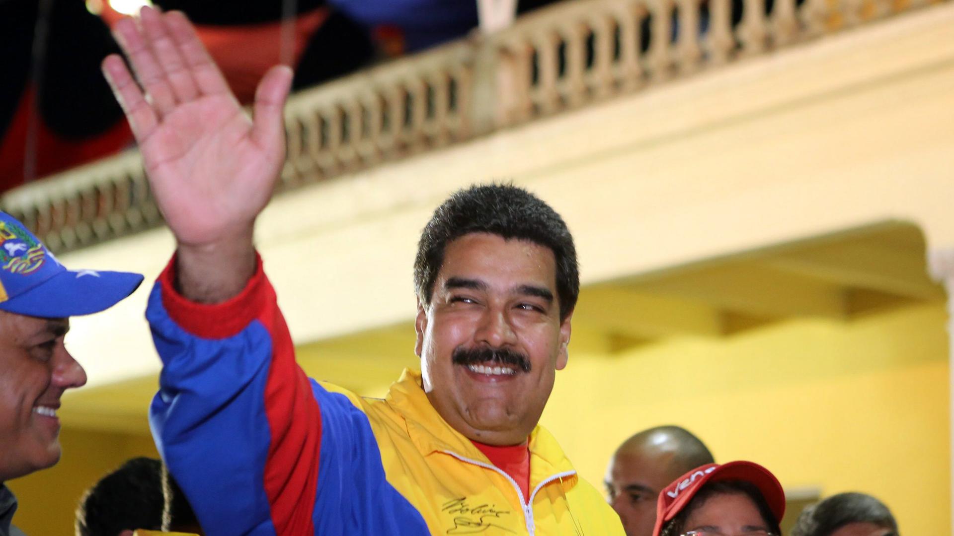 Der venezolanische Präsident Nicolas Maduro winkt am 13. Februar 2015 seinen Anhängern zu. Er trägt eine Jacke in den nationalfarben Venezuelas. Der venezolanische Präsident Nicolas Maduro winkt am 13. Februar 2015 seinen Anhängern zu. Er trägt eine Jacke in den nationalfarben Venezuelas.
