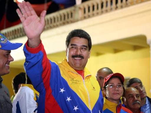 Der venezolanische Präsident Nicolas Maduro winkt am 13. Februar 2015 seinen Anhängern zu. Er trägt eine Jacke in den nationalfarben Venezuelas.