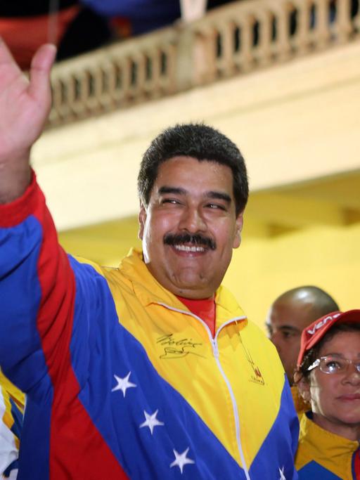 Der venezolanische Präsident Nicolas Maduro winkt am 13. Februar 2015 seinen Anhängern zu. Er trägt eine Jacke in den nationalfarben Venezuelas.