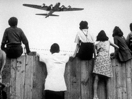Berliner Kinder beobachten 1948 einen "Rosinenbomber" beim Anflug auf den Flughafen Tempelhof.