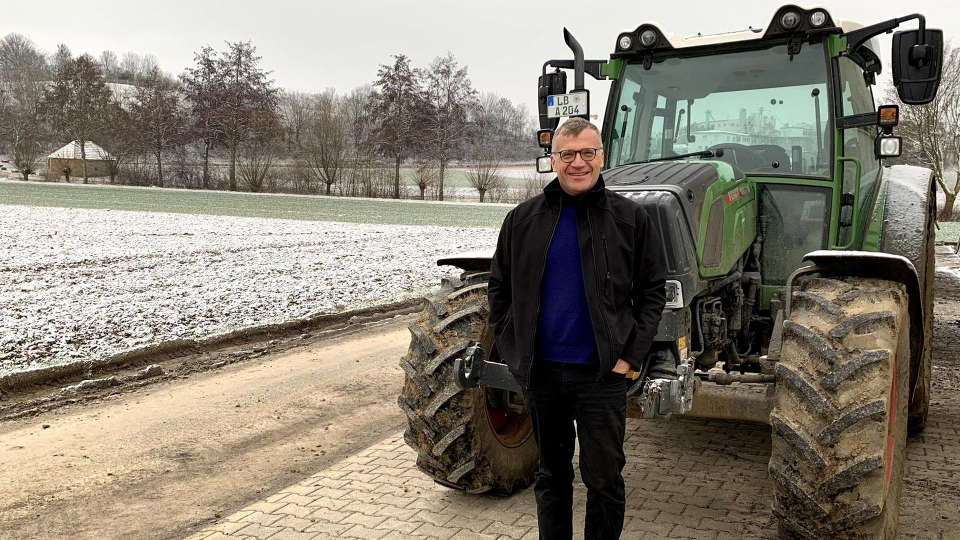 Marcus Arzt ist Ökobauer in Ditzingen und Biolandchef in Baden-Württemberg. Er steht neben seinem schneebedecktem Acker und grünem Traktor im Winter. Marcus Arzt ist Ökobauer in Ditzingen und Biolandchef in Baden-Württemberg. Er steht neben seinem schneebedecktem Acker und grünem Traktor im Winter.