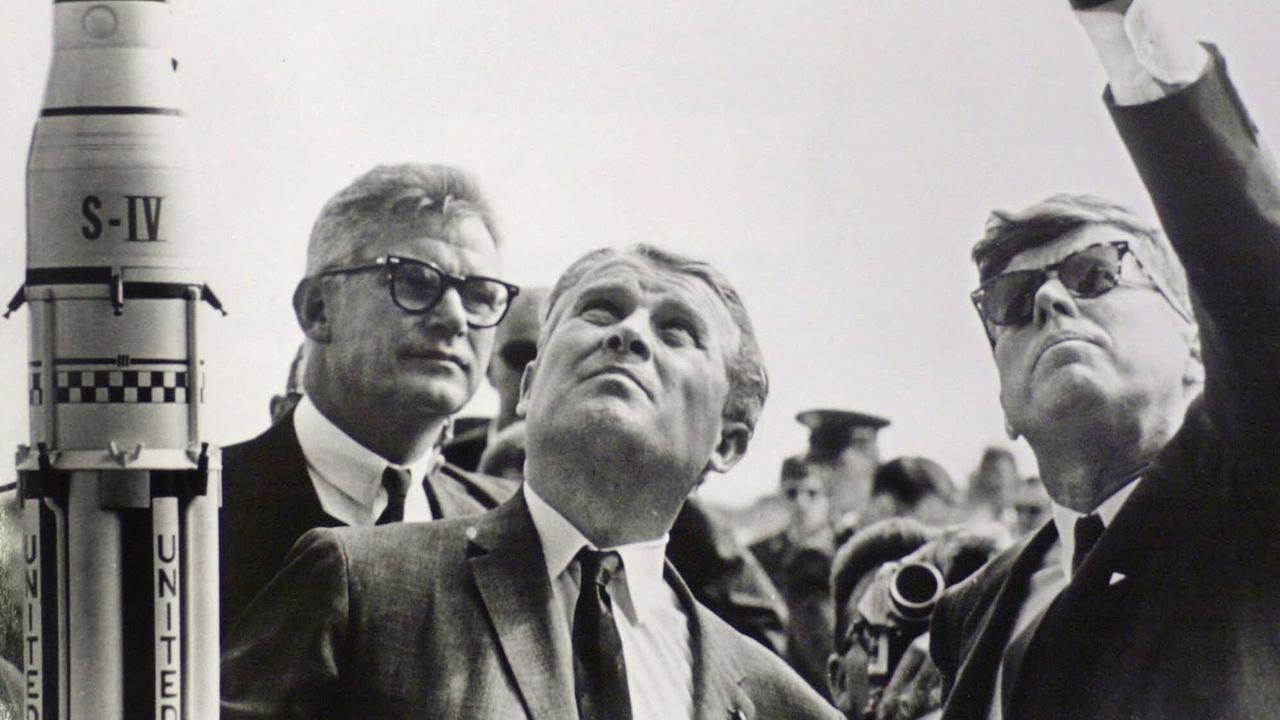 Dr. Robert Seamans, und Dr. Wernher von Braun, schauen zu, während der damalige US-Präsident John F. Kennedy in den Himmel deutet in der Cape Canaveral Air Force Station in Florida im November 1963.