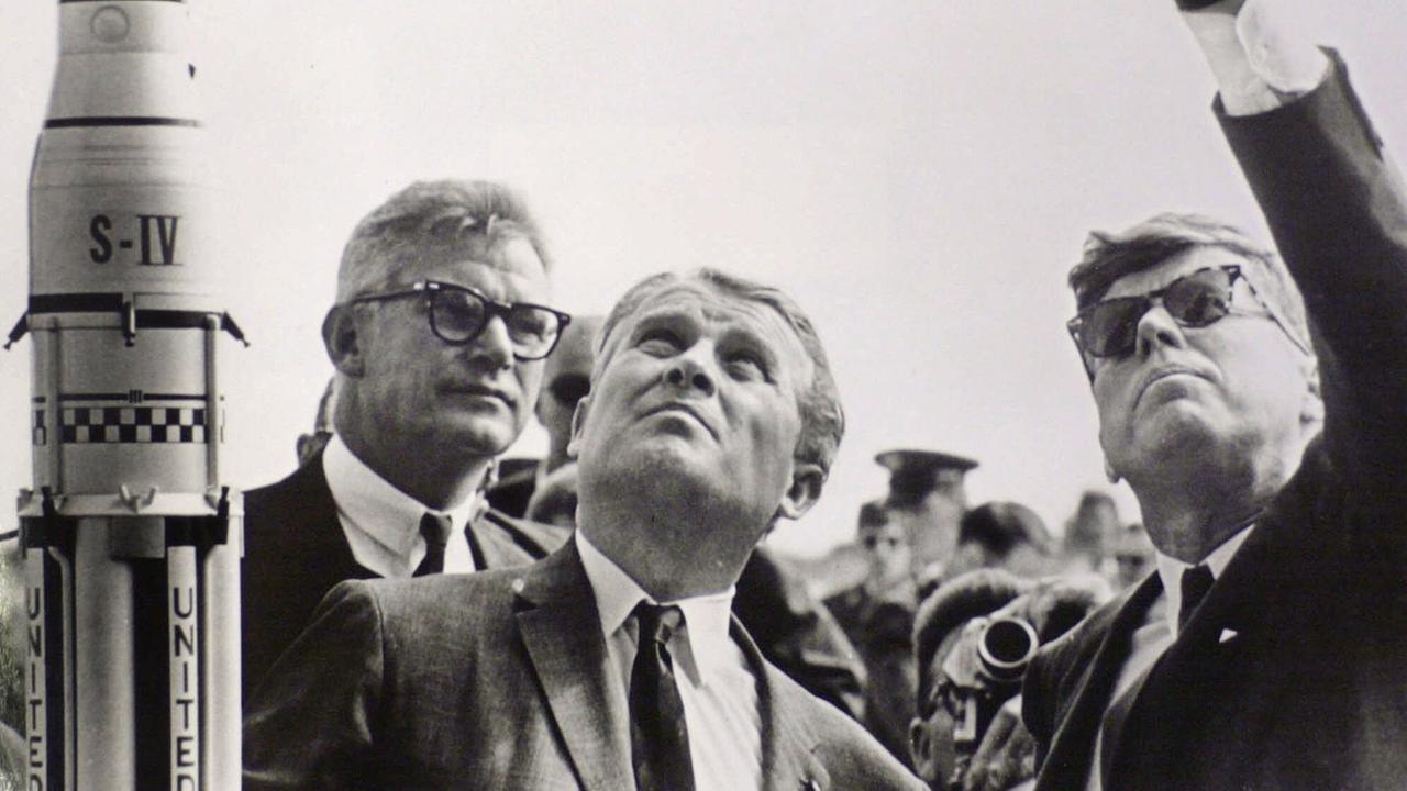 Dr. Robert Seamans, und Dr. Wernher von Braun, schauen zu, während der damalige US-Präsident John F. Kennedy in den Himmel deutet in der Cape Canaveral Air Force Station in Florida im November 1963. Dr. Robert Seamans, und Dr. Wernher von Braun, schauen zu, während der damalige US-Präsident John F. Kennedy in den Himmel deutet in der Cape Canaveral Air Force Station in Florida im November 1963.