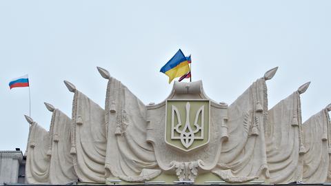 2.3.2014: Die ukrainische und die russische Fahne wehen auf dem Dach der Regionalregierung in Charkiw, Ostukraine, nachdem prorussische Demonstranten das Gebäude gestürmt haben.