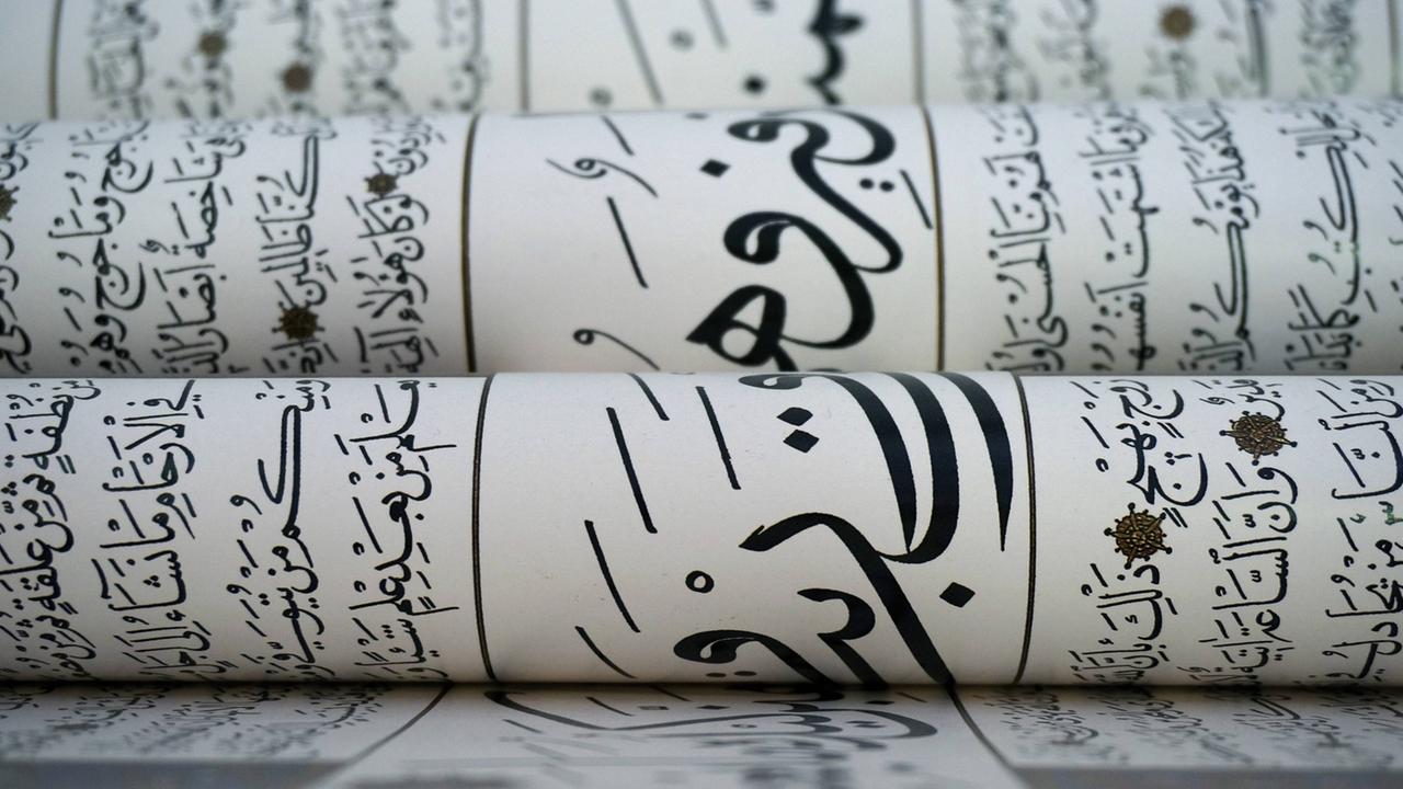 Mehrere Bögen mit arabischer Kalligrafie liegen übereinander. Mehrere Bögen mit arabischer Kalligrafie liegen übereinander.
