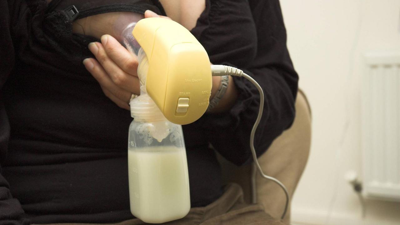 Eine Mutter benutzt eine Milchpumpe.
