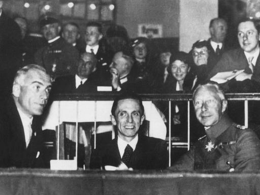 Major a.D. von Neufville, Joseph Goebbels und Kronprinz Wilhelm von Preussen sitzen an einem Tisch.