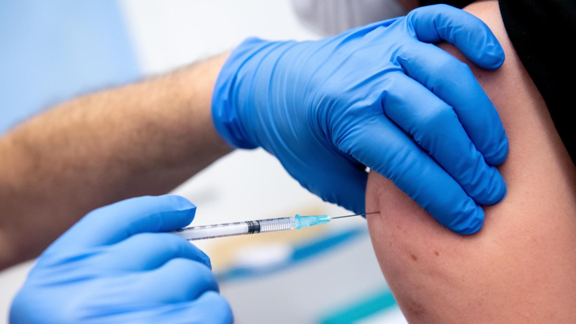 Ein Mitarbeiter der Asklepios Klinik wird von einem Kollegen mit dem Corona-Impfstoff von Biontech/Pfizer geimpft. Zahlreiche Mitarbeiter der Klinik haben sich gegen das Coronavirus impfen lassen. Ein Mitarbeiter der Asklepios Klinik wird von einem Kollegen mit dem Corona-Impfstoff von Biontech/Pfizer geimpft. Zahlreiche Mitarbeiter der Klinik haben sich gegen das Coronavirus impfen lassen.
