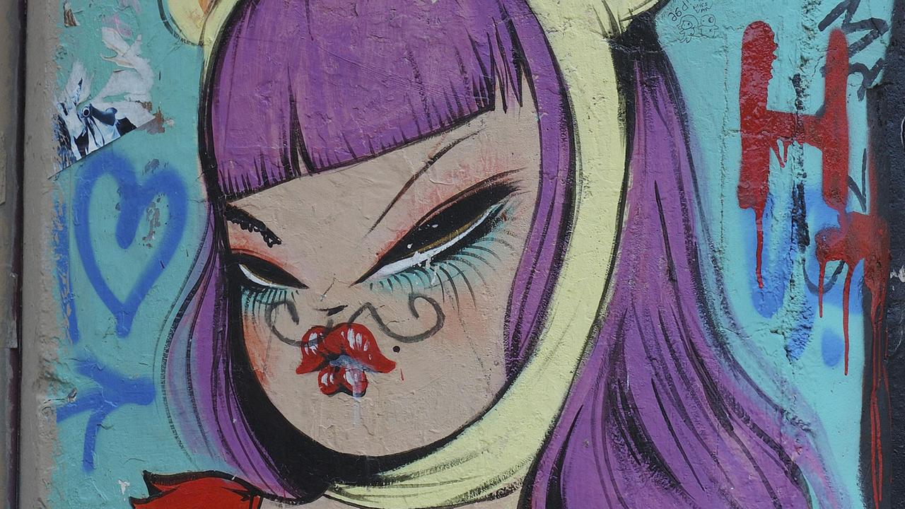 Das Graffito in Barcelona zeigt eine Comicfigur mit lila Haaren. Das Graffito in Barcelona zeigt eine Comicfigur mit lila Haaren.